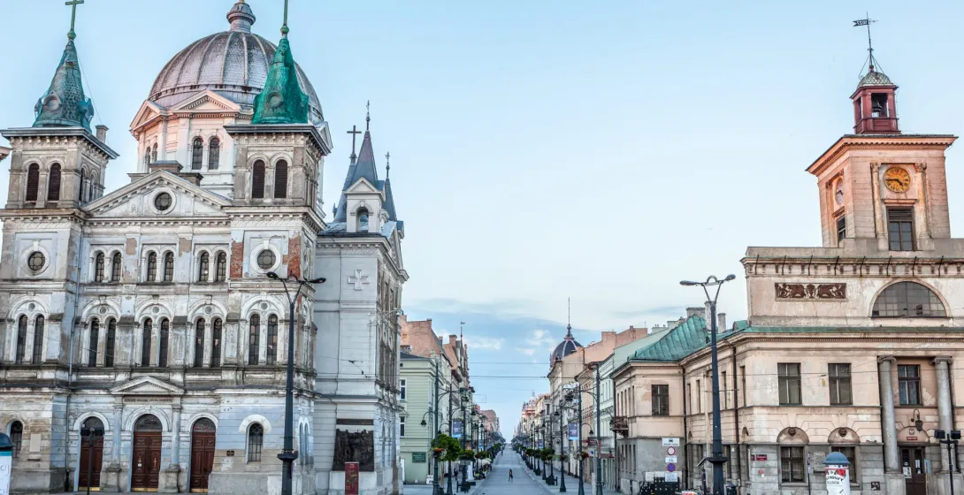 Piotrkowska Street in Łódź, with Alexander Nevsky Cathedral on the left and a building with a clock tower on the right.