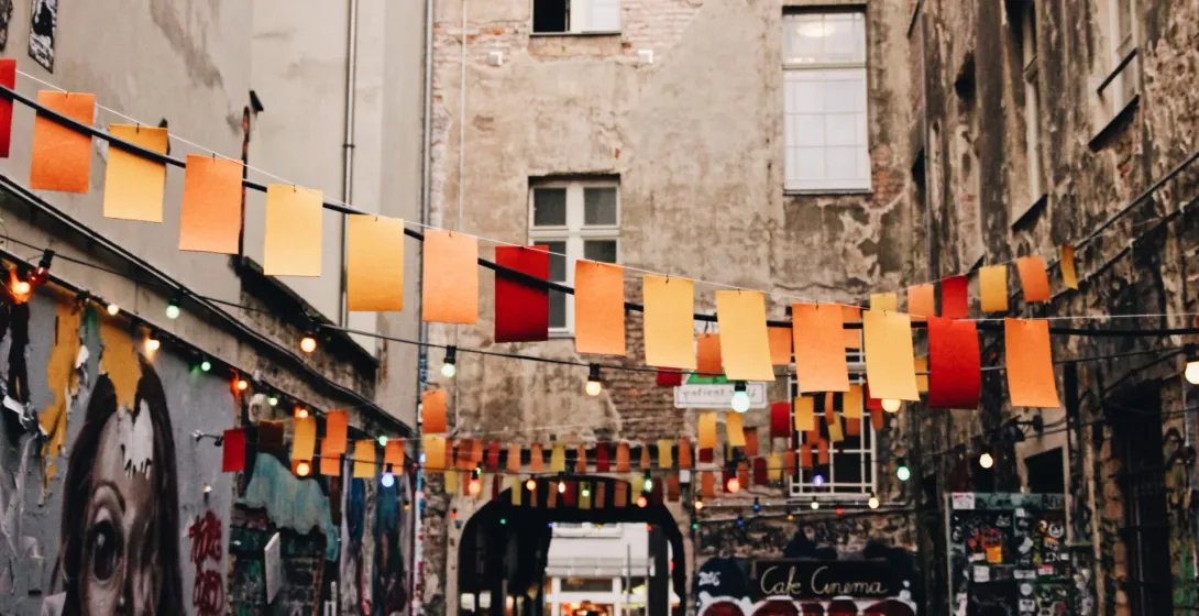 Colorful flags and string lights illuminate a charming Berlin alleyway.