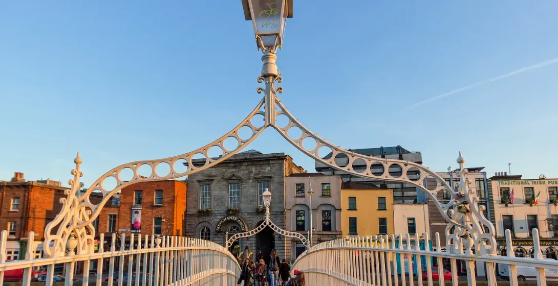 Tourists walking across the beautiful Ha'penny Bridge in Dublin, Ireland.