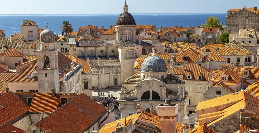 Aerial view of Dubrovnik's Old Town with terracotta roofs and the Adriatic Sea.