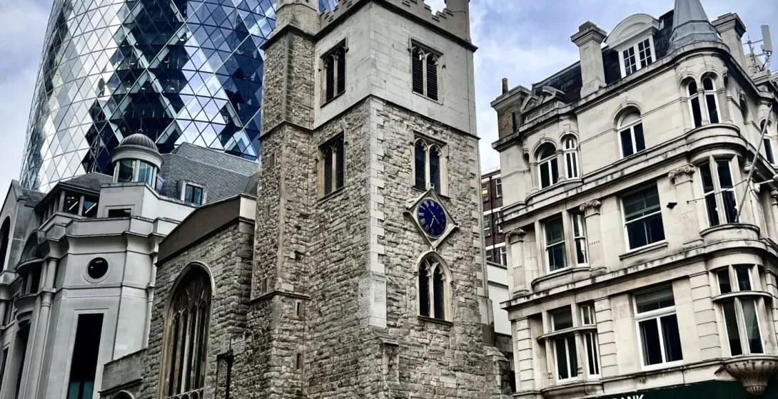 Modern and historic London architecture: The Gherkin, a church, and Lloyds Bank.