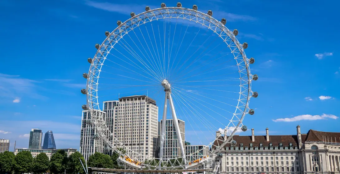 The London Eye stands tall against a clear blue sky.