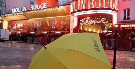 Walkative! tour guide umbrella in front of the Moulin Rouge in Paris.