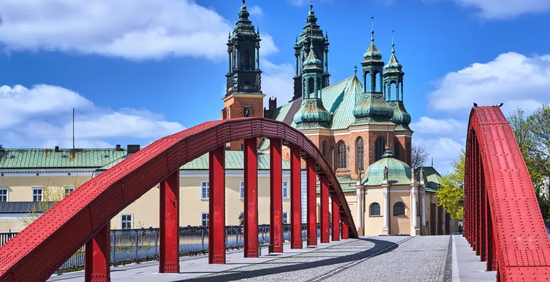 Red bridge in Poznan, Poland, with the Poznan Cathedral in the background.