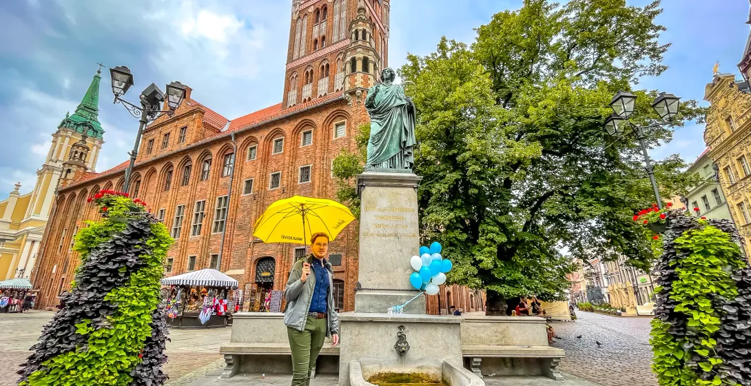 Explore Toruń's Old Town: The majestic Town Hall and Nicolaus Copernicus statue.