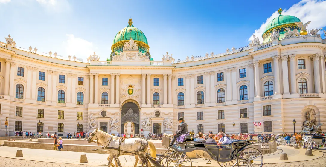 Tourists enjoy a horse-drawn carriage ride in front of Vienna's Hofburg Palace.