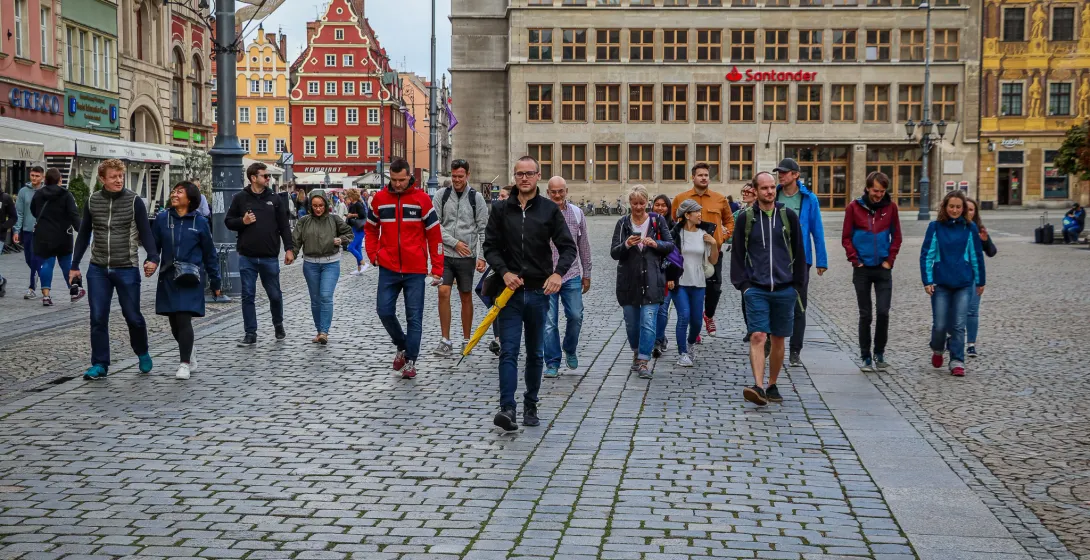 A guided walking tour group explores the historic streets of Wrocław, Poland.