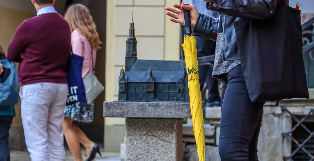 A tour guide in Wroclaw, Poland, points out dwarf statues to a group of tourists.