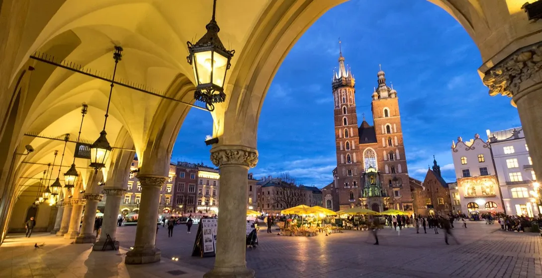 St. Mary's Basilica in Krakow's Main Market Square at dusk.