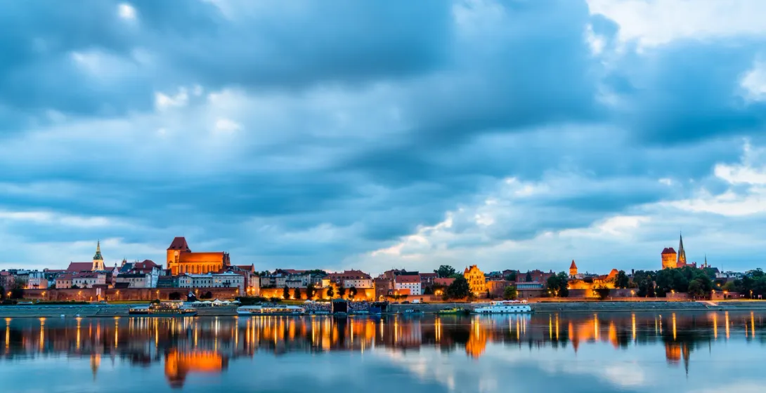Toruń skyline at twilight reflected in the river.