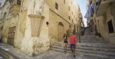 Couple walking down stairs in Valletta, Malta.