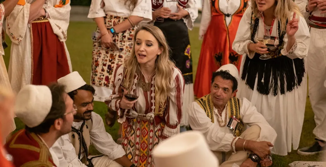 Tourists in traditional Albanian clothing enjoy an evening event.