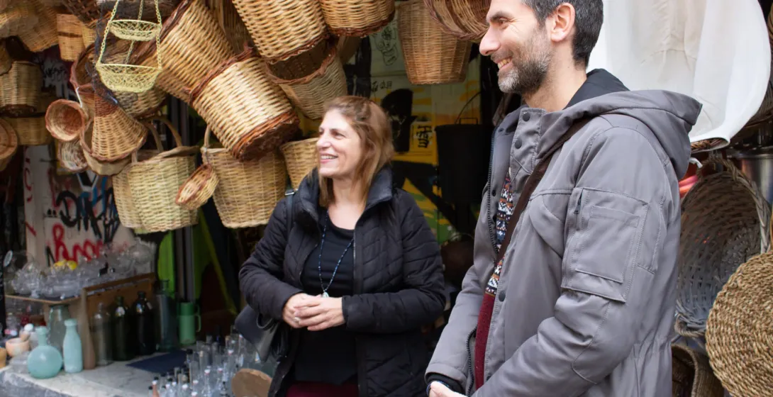 Happy couple on a guided tour in Athens, admiring traditional woven baskets.