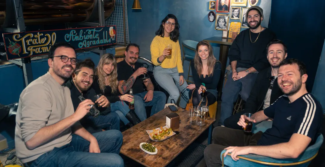 Happy tourists enjoying drinks and snacks at a Madrid bar.