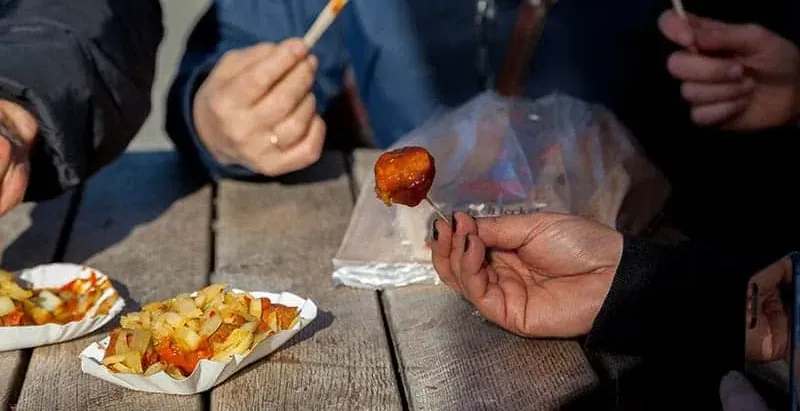 Tourists enjoying Currywurst in Berlin.