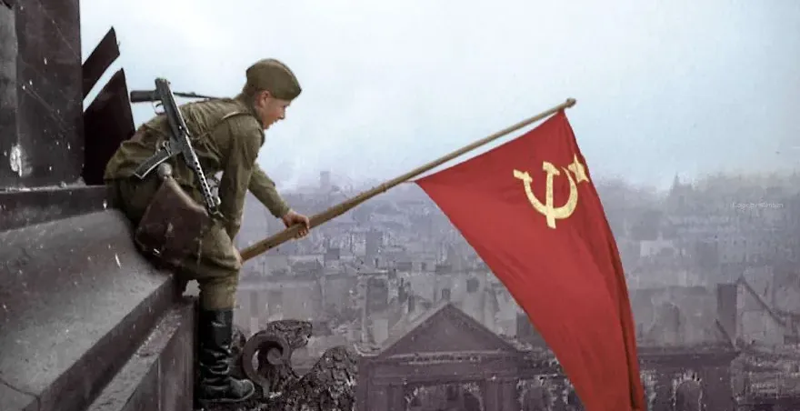 Soviet soldier raising a flag in war-torn Berlin.