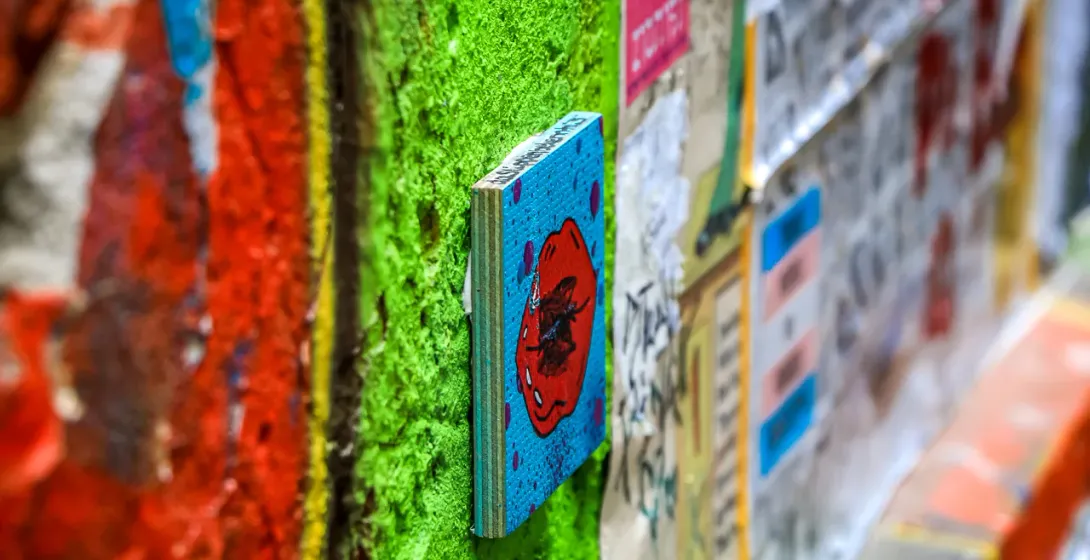 Vibrant street art in Berlin: a close-up of a painted wooden artwork.