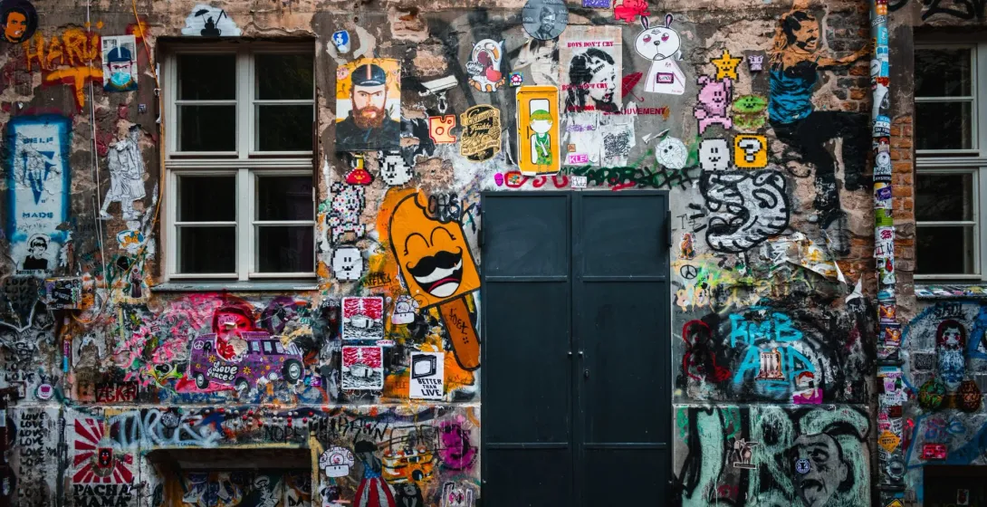 Colorful graffiti and street art cover a building wall in Berlin.