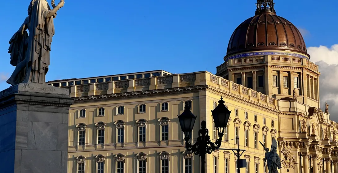 Statues and a grand building with a copper dome in Berlin, Germany.