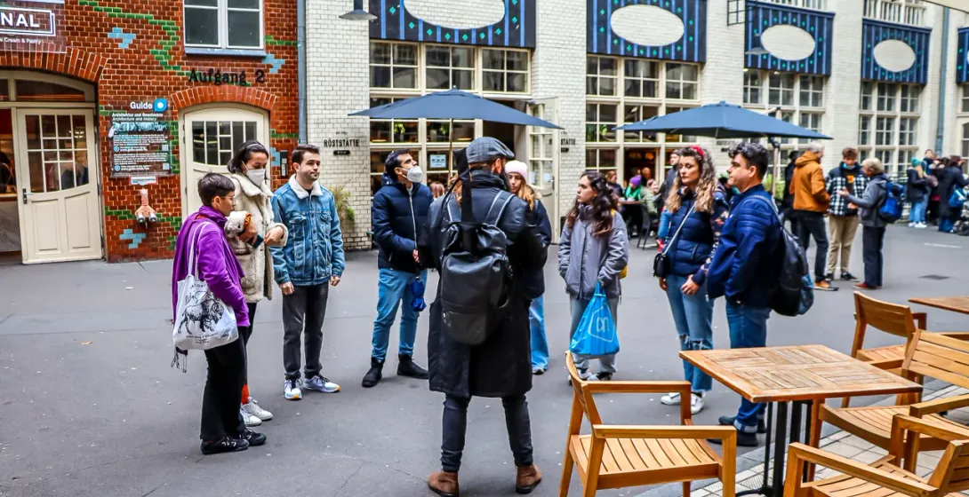A guided tour group in a Berlin courtyard.