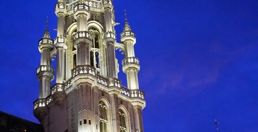 Brussels Town Hall at night, illuminated against the dark sky.
