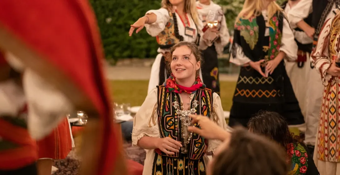 Tourists experience Romanian culture, wearing traditional clothing.