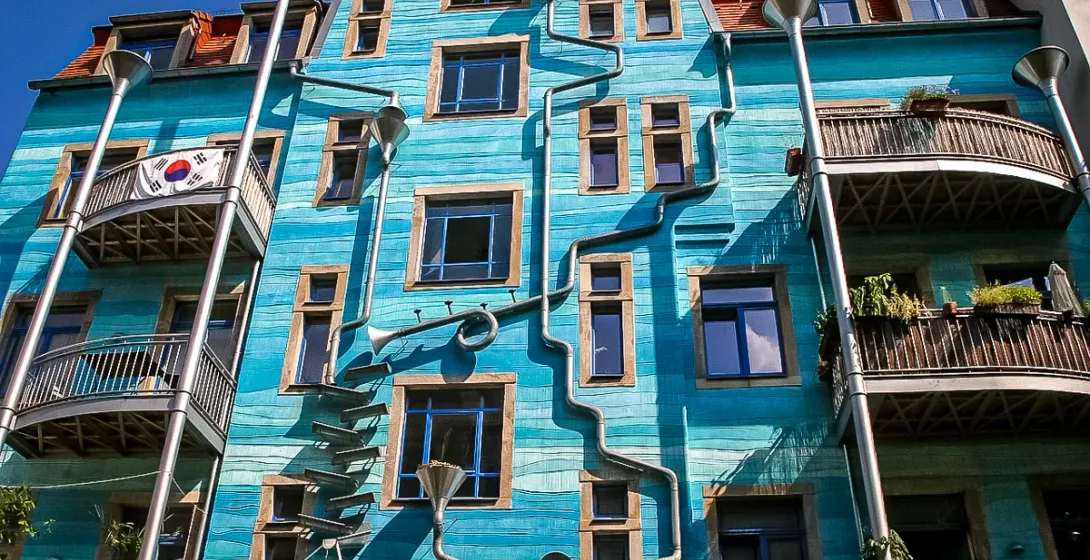 A teal building in Dresden, Germany, with unique musical instrument-shaped downspouts.