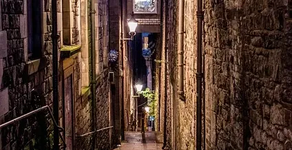Charming cobblestone alleyway in Edinburgh at night.