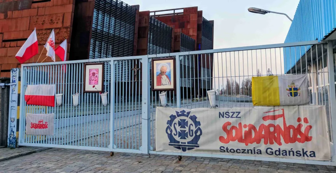 Gate to the European Solidarity Centre in Gdansk, Poland, with Solidarity banners and flags.