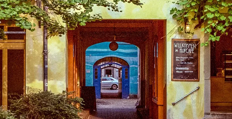 Picturesque archway leading to a hidden courtyard cafe in Germany.