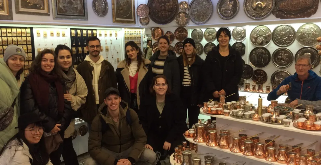 Happy tour group in an Istanbul shop, surrounded by beautiful copperware.