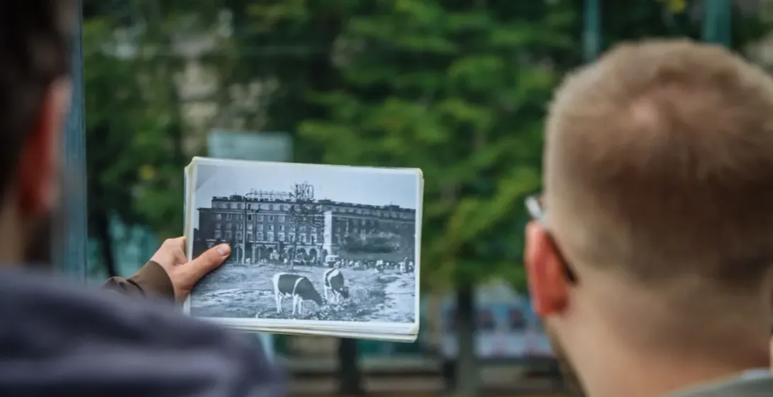 A guided tour in Krakow, Poland, showing a historical photo of a building.