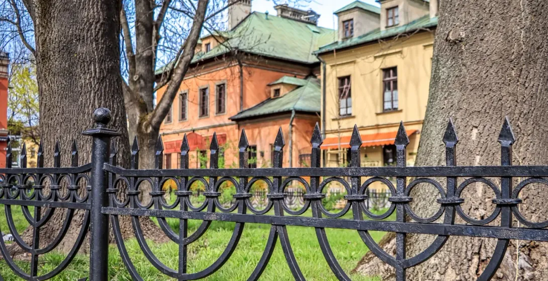 Ornate wrought-iron fence with menorah design in Krakow's Kazimierz district.