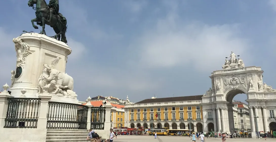 Tourists exploring Praça do Comércio in Lisbon, Portugal.