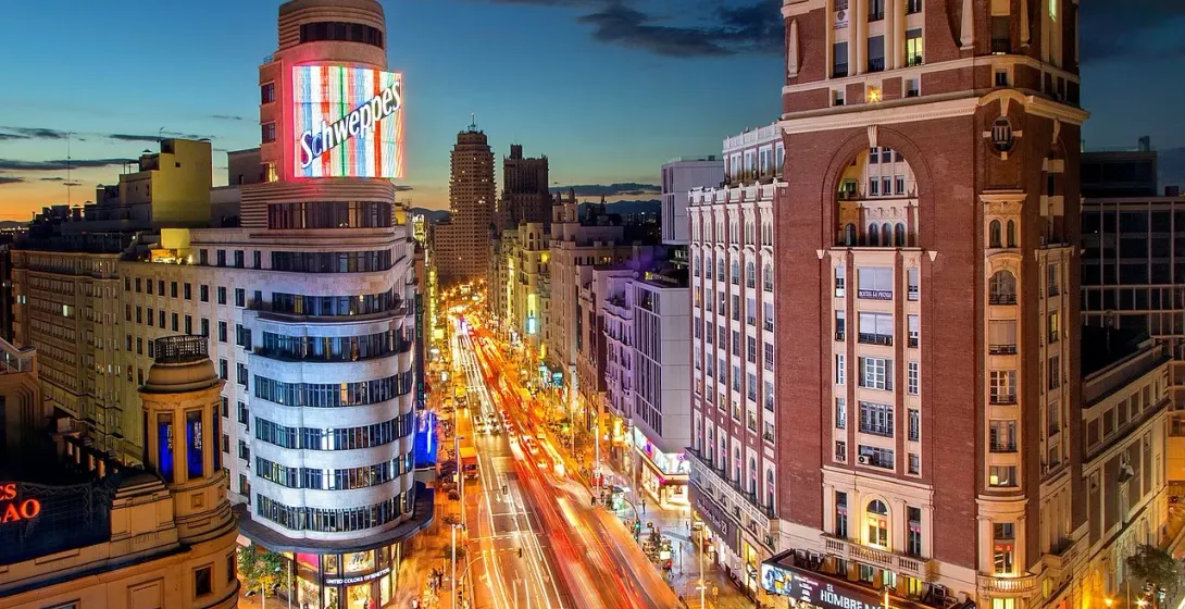 Night view of Madrid's Gran Vía, showcasing its vibrant architecture and bustling street life.