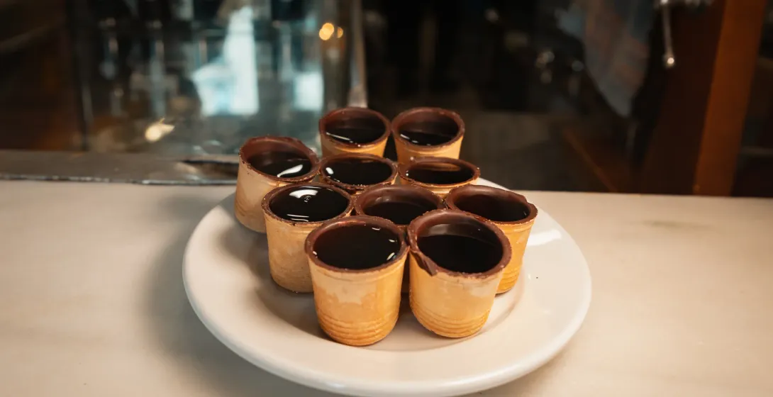 Chocolate-dipped waffle cups filled with a dark liquid in Madrid.