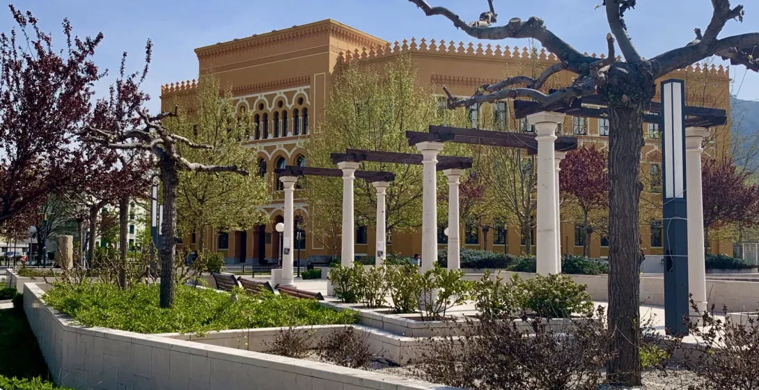 Serene park in Mostar, featuring a beautiful yellow building.