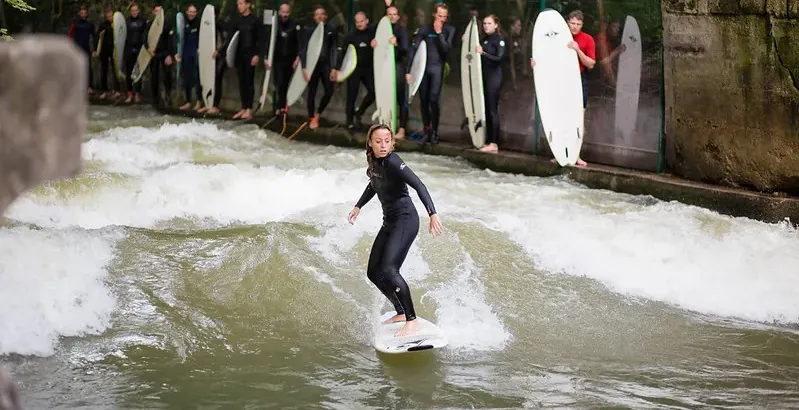 Surfer riding a wave at the Eisbach wave in Munich.