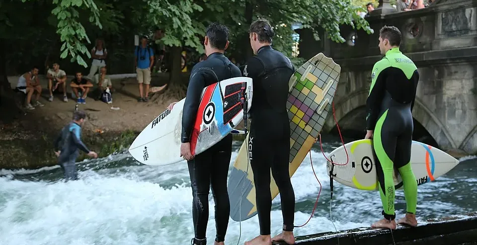 Surfers prepare to ride the Eisbach wave in Munich's Englischer Garten.