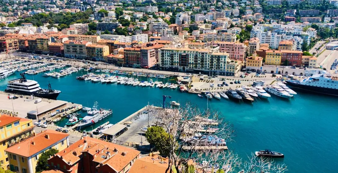 Panoramic view of Nice's harbor, filled with yachts and boats.