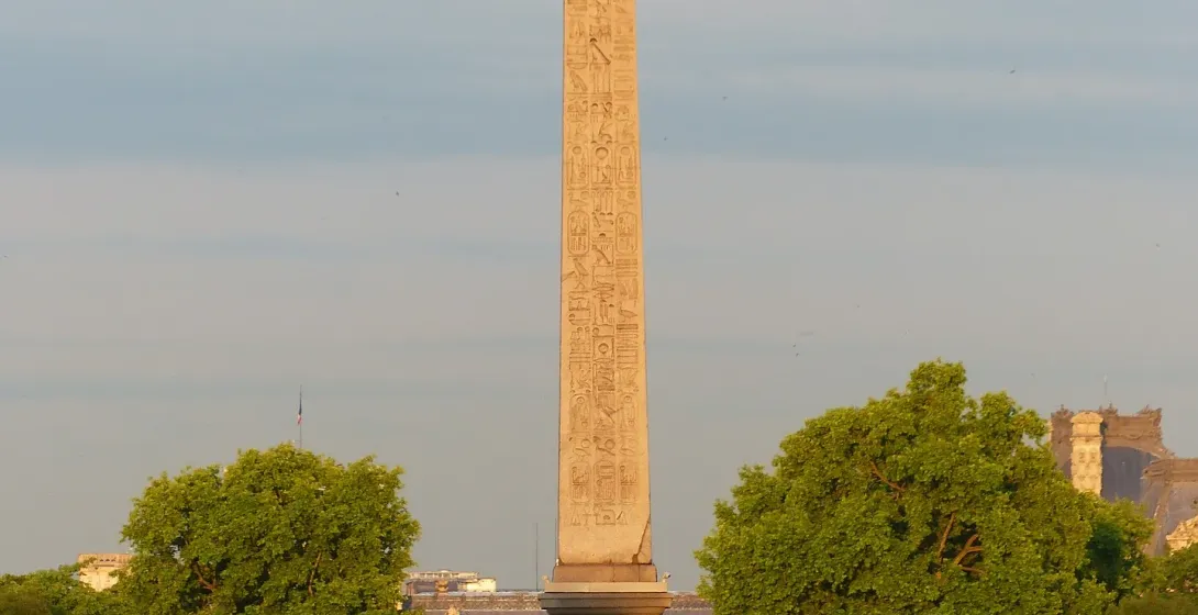 The Luxor Obelisk in Paris, France, stands tall amidst city traffic.