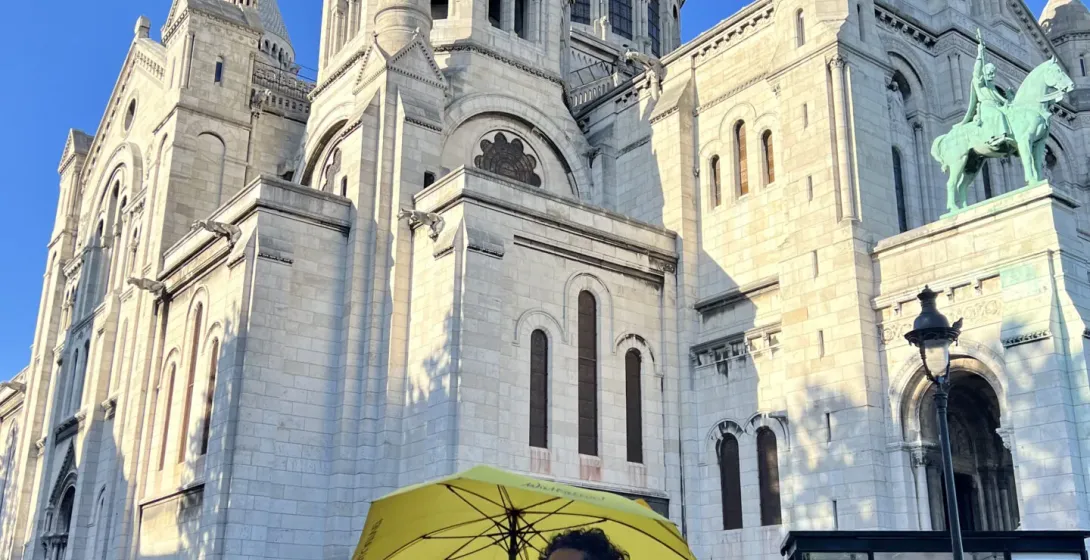 A tour guide in Paris stands before the Sacré-Cœur Basilica in Montmartre.