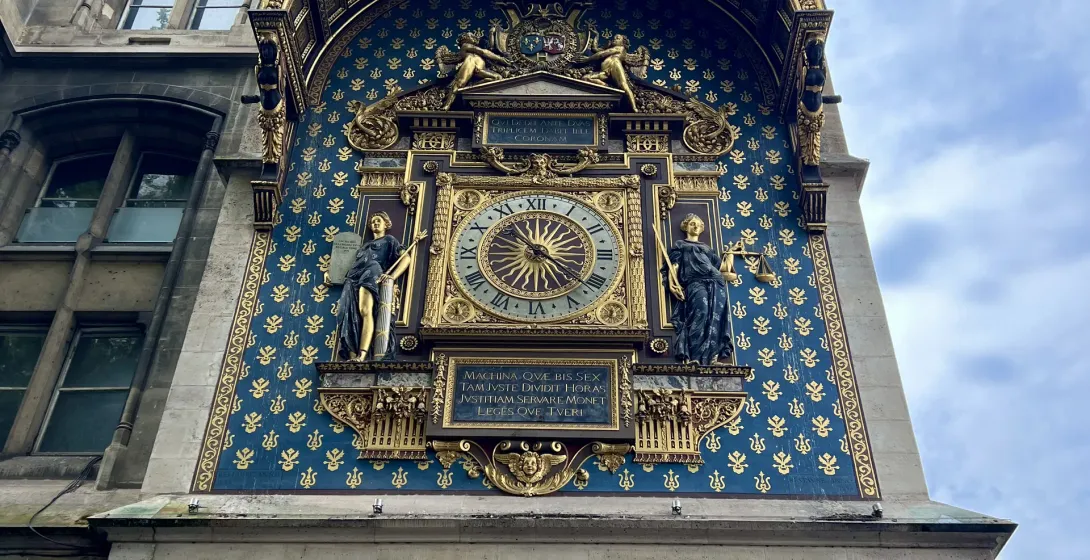 Intricate astronomical clock on a building facade in Paris.