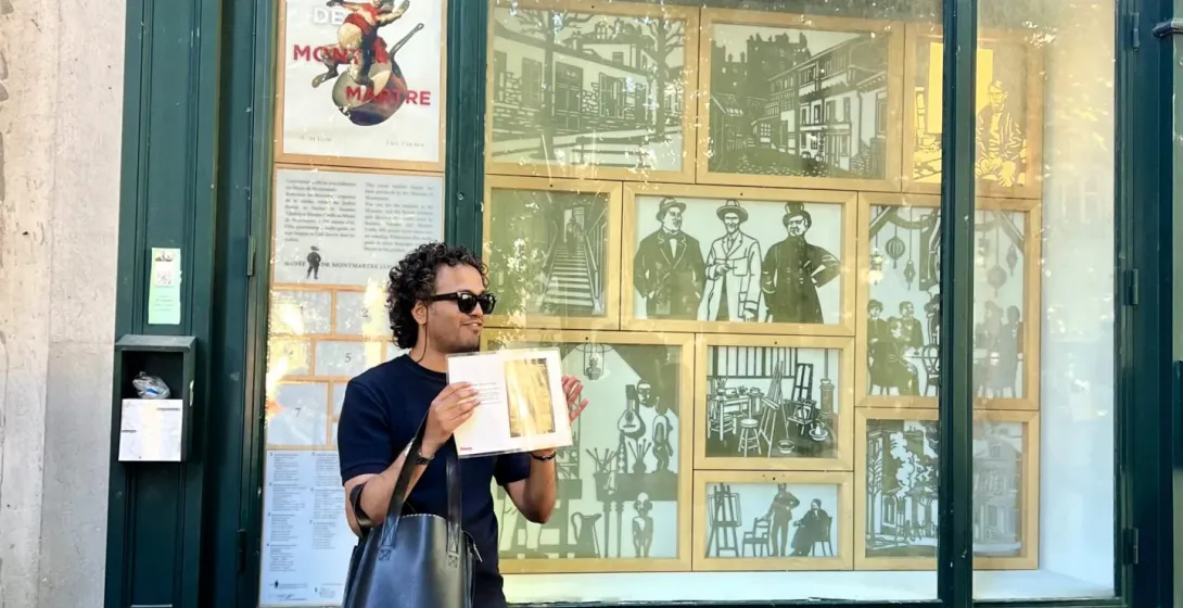 A tourist explores Montmartre, Paris, standing outside Le Bateau Lavoir, a historic building.