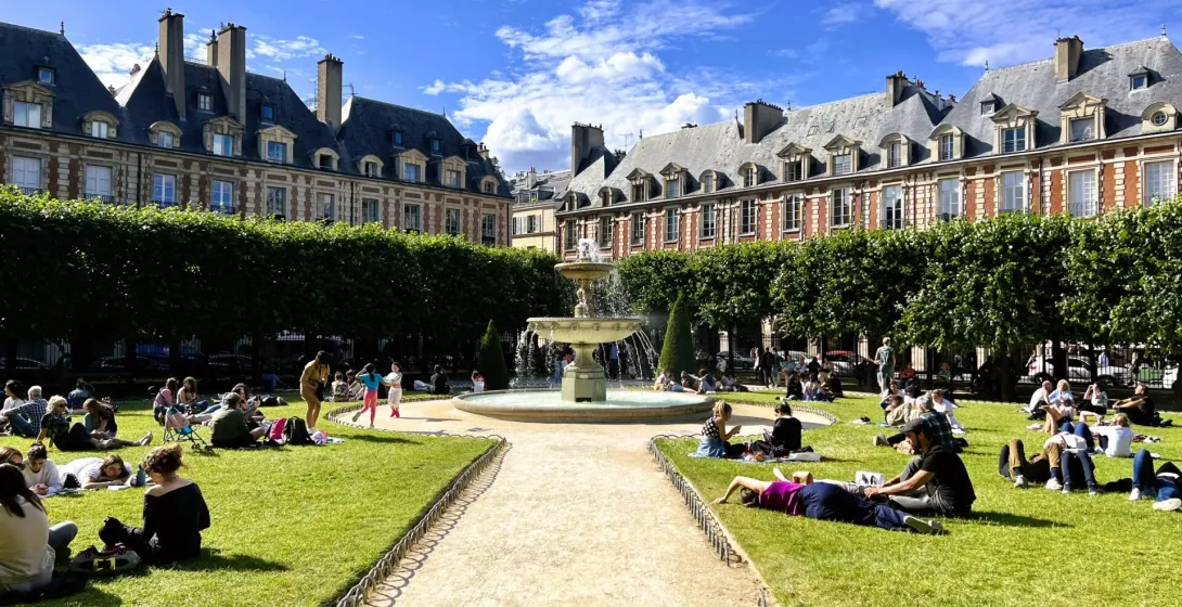 People relaxing in a sunny Parisian square.