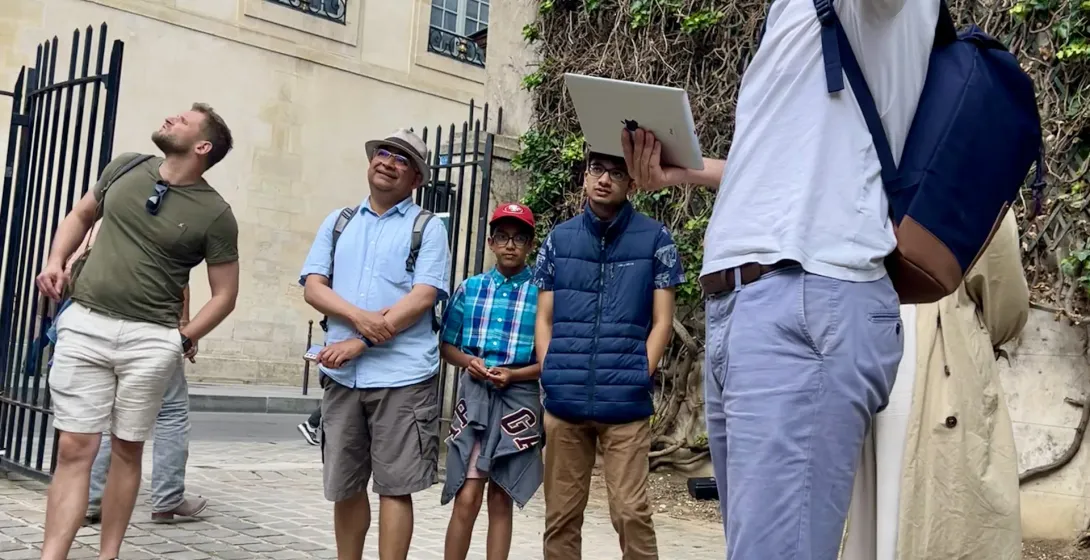 A tour guide leads a group on a walking tour in Paris.