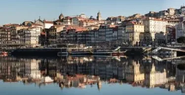 Panoramic view of Porto's Ribeira district reflected in the Douro River.