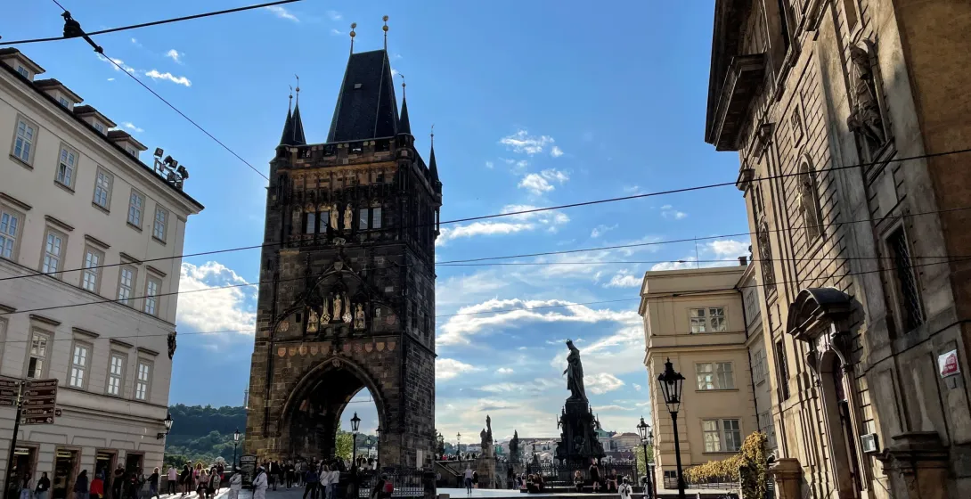 Tourists enjoying the view of the Lesser Town Bridge Tower in Prague.