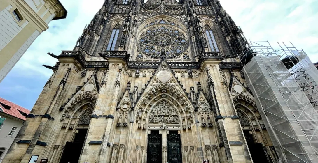 A tour group stands before the magnificent St. Vitus Cathedral in Prague Castle.