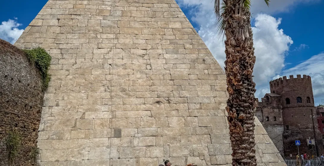 Tourists exploring the Pyramid of Cestius in Rome.